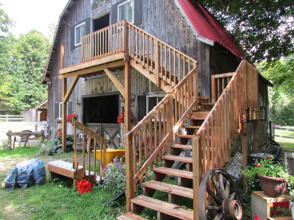 Custom exterior staircase and deck built onto a barn by Tandem Projects